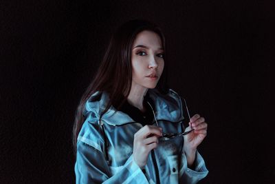 Portrait of a beautiful young woman over black background