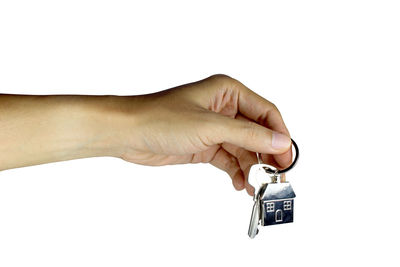 Close-up of hand holding eyeglasses against white background