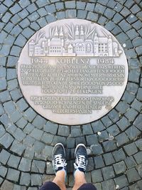 Low section of person standing on tiled floor