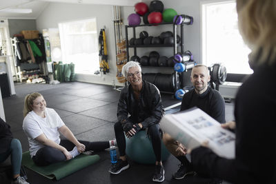 Smiling people talking together in gym