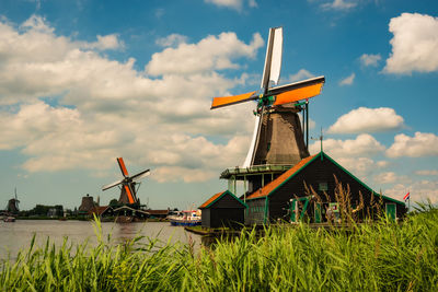 Traditional windmill on field against sky