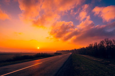 Empty road against sky during sunset