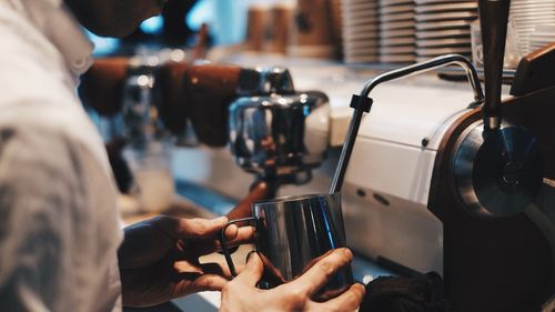 Close-up of hand holding coffee at cafe