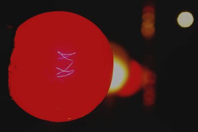 Close-up of light bulb over black background