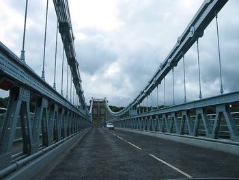 View of suspension bridge against cloudy sky
