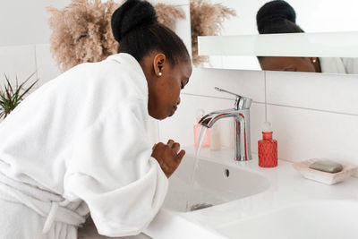 Side view of woman in bathroom at home