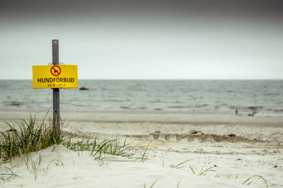 Close-up of information sign on beach