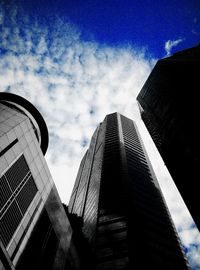 Low angle view of modern building against cloudy sky