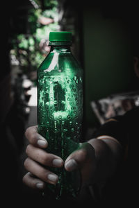 Close-up of hand holding glass bottle