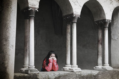 Portrait of woman leaning on retaining wall