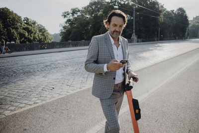 Businessman renting an e-scooter in the city