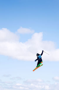 Low angle view of man paragliding against sky