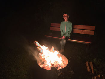 Man sitting with fire crackers at night