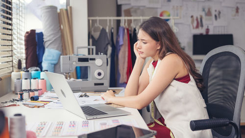 Woman using mobile phone while sitting on table