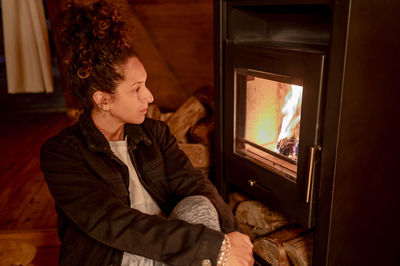 Side view of young man sitting on fire