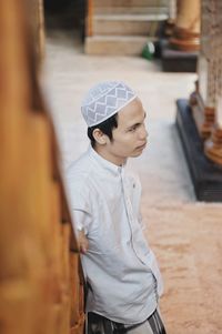 High angle view of man looking away while standing against railing at home