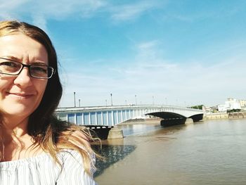 Portrait of man against bridge over river against sky