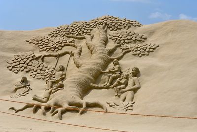 Low angle view of sculpture on desert against sky