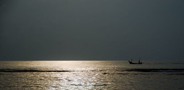 Silhouette person in sea against clear sky