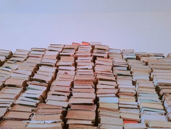 Low angle view of stack of books against sky