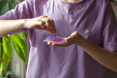 Woman hands hold purple hydrogel eye patches. ready for use cosmetics against wrinkles and puffiness