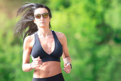 Woman wearing sunglasses running outdoors