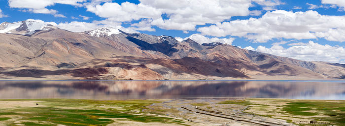 Scenic view of lake by mountains against sky