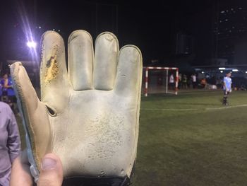 Close-up of hand holding illuminated lighting equipment at night