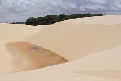 Sand dunes in desert against sky