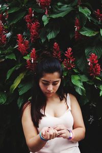 Close-up of woman against flowering plants in park