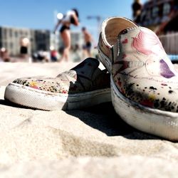 Close-up of shoes at beach