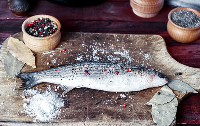 High angle view of fish by spices on table