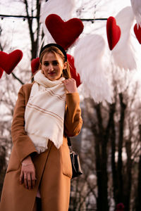 Portrait of smiling young woman with arms raised