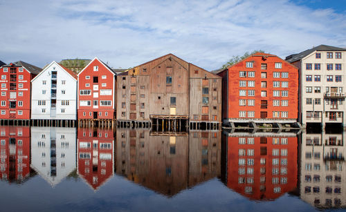 Reflection of buildings on river against sky