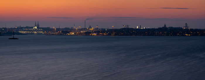 City at waterfront during sunset with vivid sky