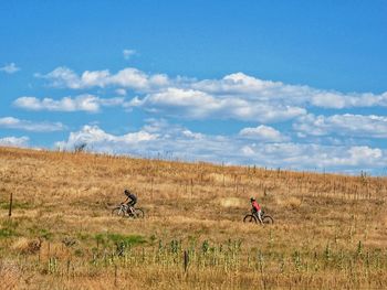 Scenic view of grassy field against cloudy sky