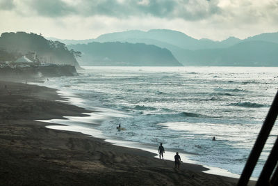 Scenic view of sea and mountains against sky