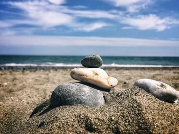 Surface level of stones on beach against sky