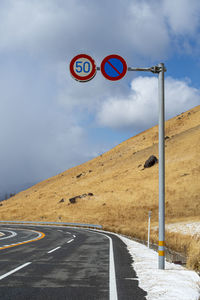 Low angle view of road against sky and yellow grass