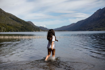 Rear view of woman standing in lake