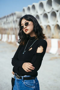 Young woman wearing sunglasses standing on land