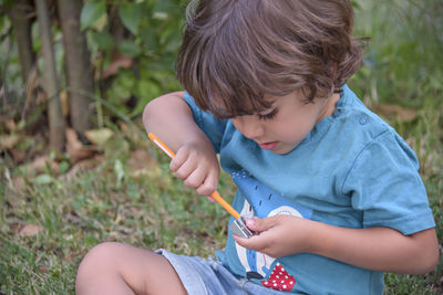 Elementary school age boys love to paint in parks. boys are drawing pictures as an outdoor hobby.