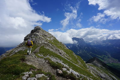 Man climbing on mountains against sky