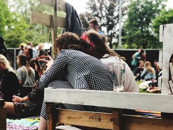 Rear view of people sitting on bench