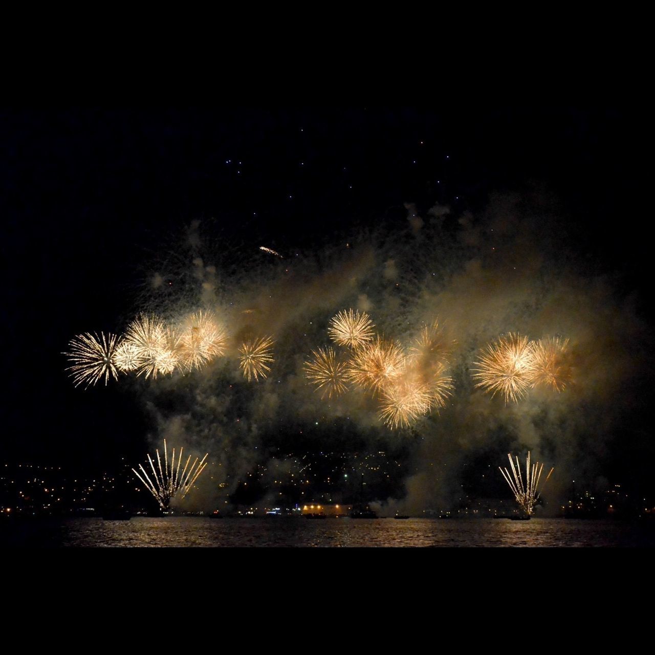 night, long exposure, illuminated, motion, glowing, sky, firework display, sparks, exploding, water, smoke - physical structure, blurred motion, fire - natural phenomenon, firework - man made object, dark, firework, silhouette, light - natural phenomenon, power in nature, arts culture and entertainment