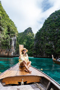 Man sitting on boat against sea