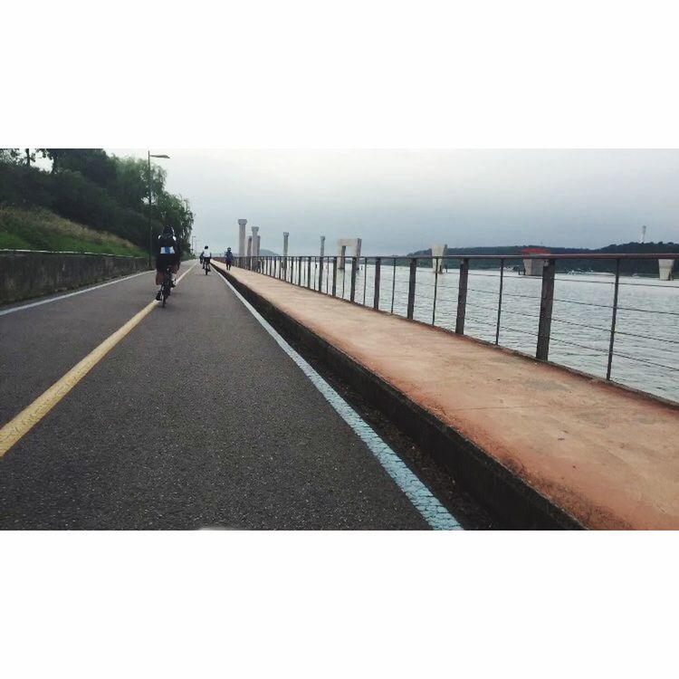 transportation, the way forward, sea, railing, water, sky, diminishing perspective, road marking, built structure, road, vanishing point, architecture, transfer print, clear sky, incidental people, day, auto post production filter, outdoors, empty, horizon over water