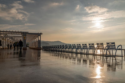 Pier over sea against sky during sunset