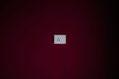 Electrical outlet on maroon wall