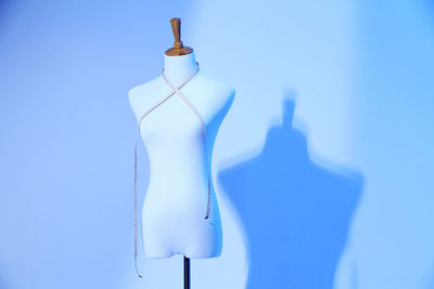 Tape measure on mannequin against wall